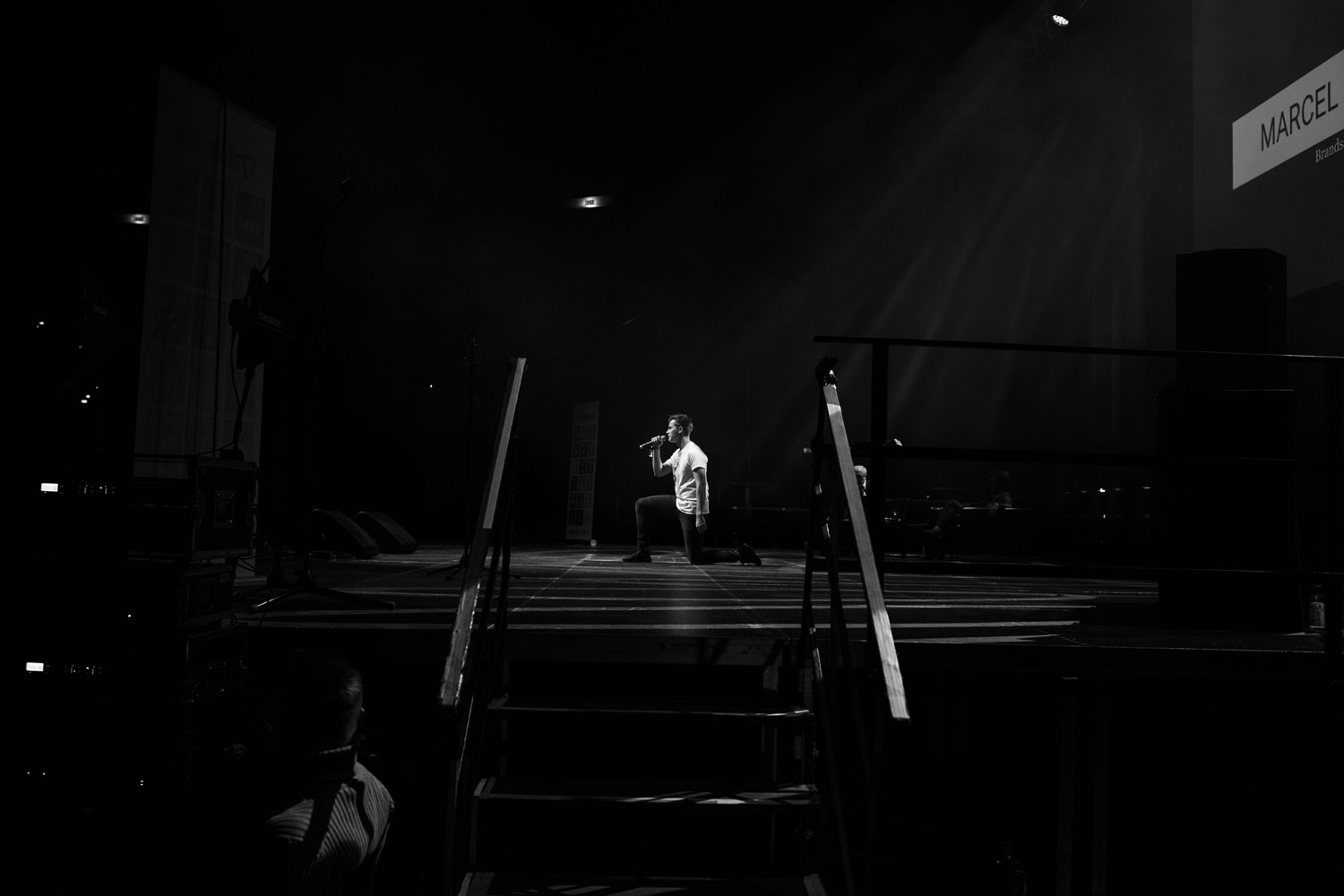 Bild von Marcel Schneuer kniend auf einer Bühne